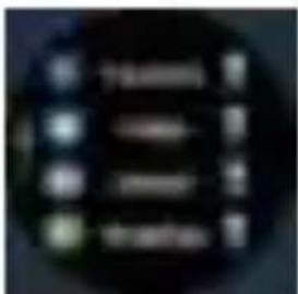 Blurred image of a dark circular object with indistinct yellow and blue symbols, possibly a label or icon.