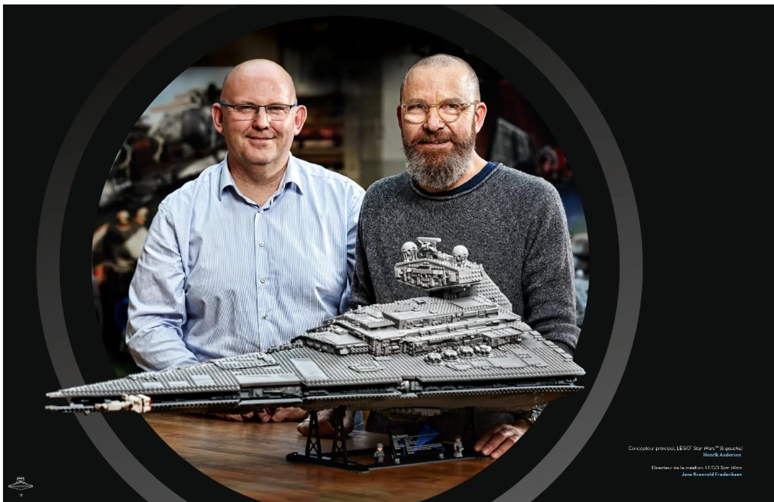 Two men posing with a detailed LEGO Star Wars model in a studio setting (no visible text or symbols on the model itself)