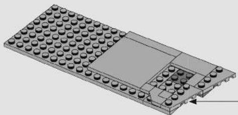 3D diagram of a LEGO base with embedded components and a small rectangular block (no text or symbols)