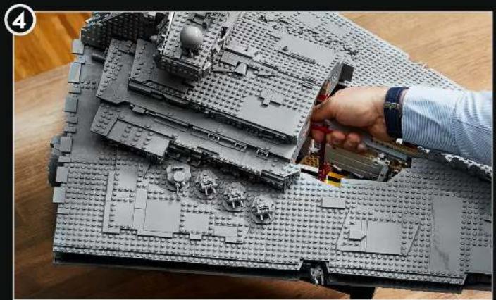 Hand assembling a LEGO building model with visible structural details (no text or symbols)
