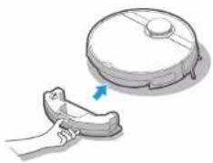 Illustration of a hand holding a small object next to a large circular device with an arrow pointing to it (no text or symbols present)