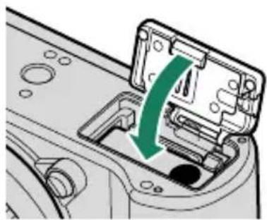 FUJIFILM X-T50 - Fermez le couvercle du compartment de la batterie et faites glisser le loquet du compartment de la batterie en position fermée. - 1
