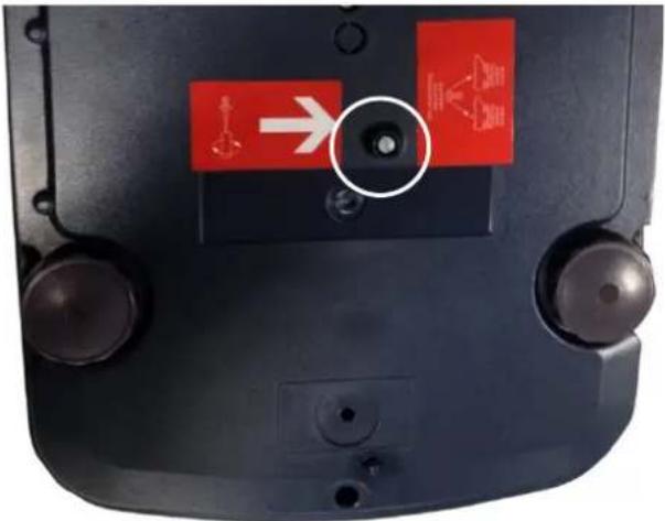 Close-up of a device's front panel showing red warning signs with icons and a white circle highlighting a bolt symbol.