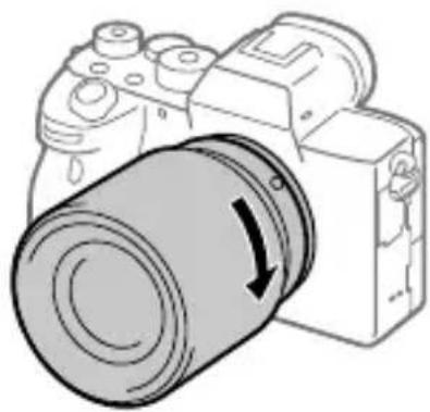 SONY Alpha ILCE-7RM4 - Samtidig med at du presser objektivet lett mot kameraet vender du objektivet sakte i pilretningen til du hører et klikk i låst posisjon. - 1