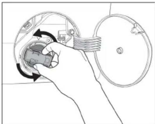 Hand inserting a component into a circular device (no text or symbols visible).