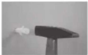 Black and white photo of a small object on a stand, possibly a lamp or mechanical component (no visible text or symbols)