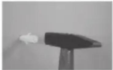 Black and white photo of a small white object on a stand, possibly a light source or abstract shape (no text or symbols visible)