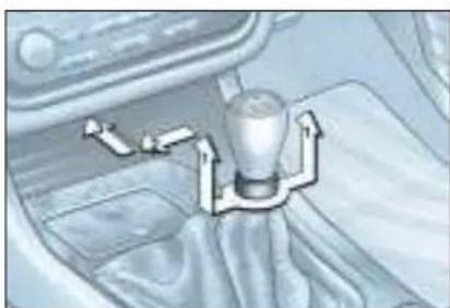 Interior view of a car showing a glass cup with directional arrows, no visible text or symbols