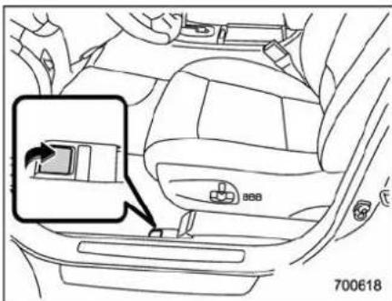 Diagram of car interior showing seatbelt switch and battery compartment with magnified view