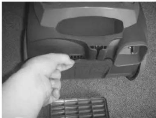Hand placing a small object into a car interior (no visible text or symbols)