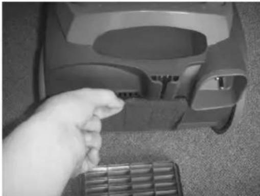 Hand placing a small object into a device component (no visible text or symbols)
