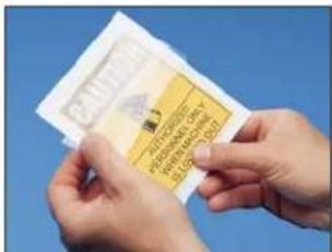 Close-up of hands holding a yellow warning sign with text against a blue background, likely a medical or educational material.