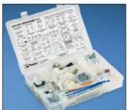Open mechanical assembly kit with labeled parts and specifications on both sides