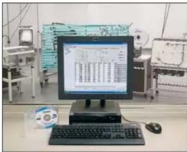 Lab setup photo showing a computer monitor displaying a report with technical data, keyboard, mouse, and CD/DVD nearby