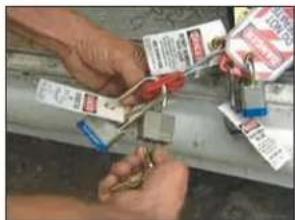 Close-up of hands using a tool to adjust or install electronic components with visible labels and parts