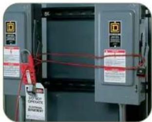 Photo of electrical equipment with red cables and warning labels, showing control panel and warning text
