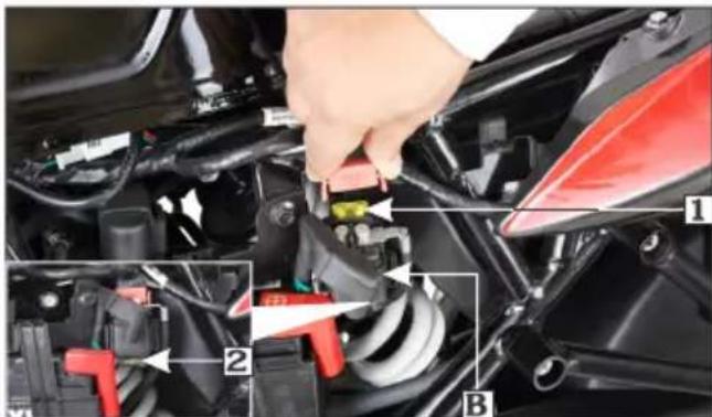 Close-up mechanical assembly diagram showing a hand adjusting a component with labeled parts 1, 2, and B