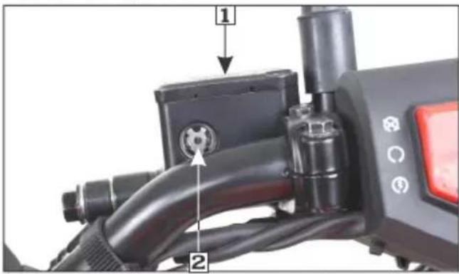 Close-up of a black electric vehicle charging plug with labeled parts and control buttons
