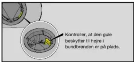 Kontroller, at den gule beskytter til højre i bundbrønden er på plads.