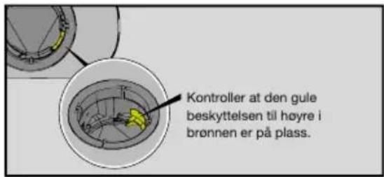 Kontroller at den gule beskyttelsen til høyre i brønnen er på plass.