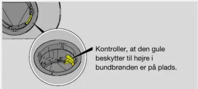 Kontroller, at den gule beskytter til højre i bundbrønden er på plads.