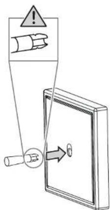 Safety warning diagram showing a hand holding a device with warning symbol and directional arrow indicating safety instructions.