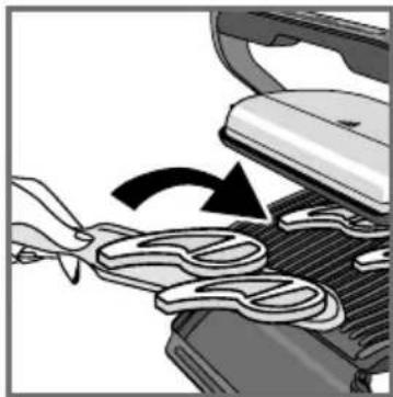 Close-up of a hand using a tool to press or spread material on a mechanical component, with no visible text or symbols.