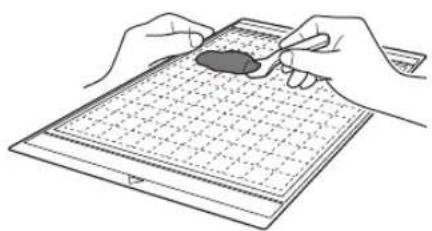 Illustration of hands holding a small object over a grid-patterned sheet (no text or symbols)