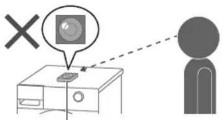 Diagram showing a device with a screen and a person silhouette, including a 'X' symbol and dashed line indicating connection or alignment.