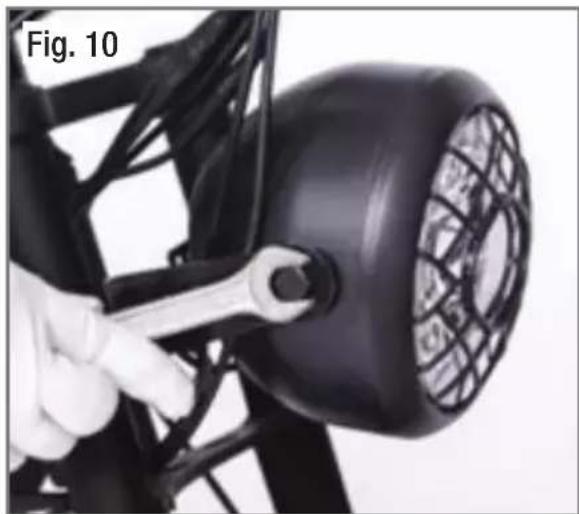 Close-up of a hand using a wrench to adjust a black electronic device with a mesh grille (no visible text or symbols)