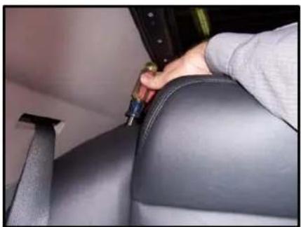 Close-up of a person's seatbelt being adjusted for a cable, no visible text or symbols