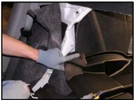 Person wearing gloves handling a dark fabric or material on a car wheel (no visible text or symbols)