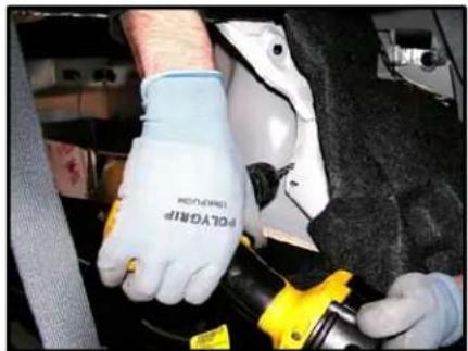 Close-up of gloved hands adjusting a car engine component (no visible text or symbols)