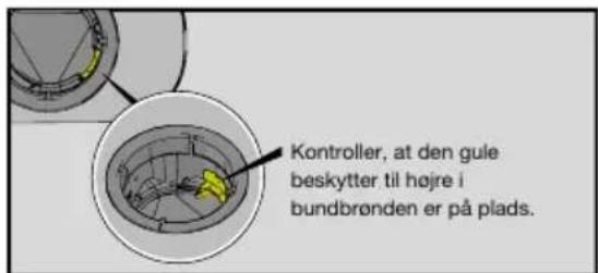 Kontroller, at den gule beskytter til højre i bundbrønden er på plads.