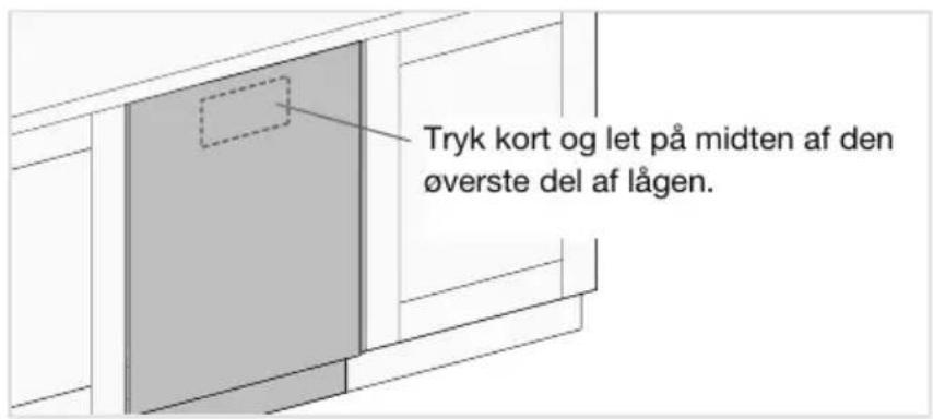 Tryk kort og let på midten af den øverste del af lågen.