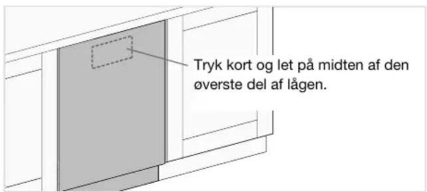 Tryk kort og let på midten af den øverste del af lågen.