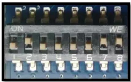 Close-up of a black electronic component with multiple terminals and metallic contacts (no visible text or symbols)