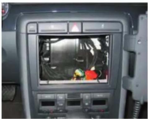 Interior view of a vehicle dashboard with a central touchscreen display showing internal components (no visible text or symbols)