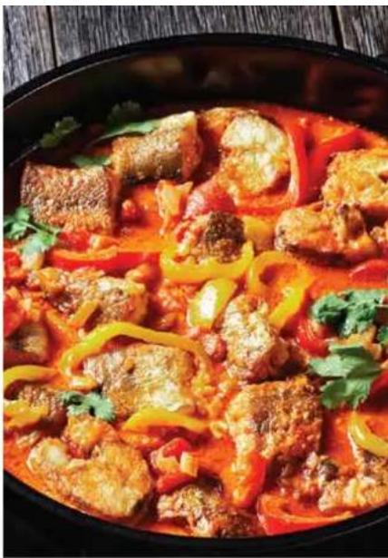 Close-up of a stewed dish with meat and chili peppers in red sauce, garnished with cilantro (no text or symbols visible)