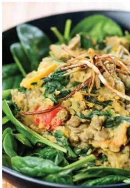 Close-up of a bowl of stir-fried greens with visible vegetable toppings (no text or symbols)