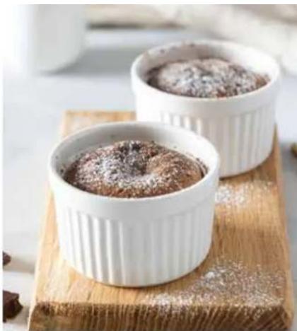 Two white fluted chocolate rins on a wooden board, one with powdered sugar dust (no text or symbols visible)