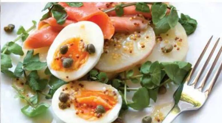 Salad with sliced lettuce, pickled egg, and garnished with parsley and green herbs (no text or symbols visible)