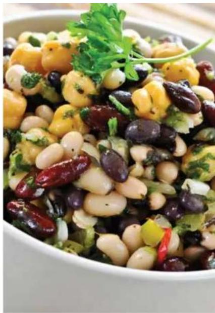 Close-up of a colorful salad dish with beans, red dates, and herbs in a bowl (no text or symbols visible)
