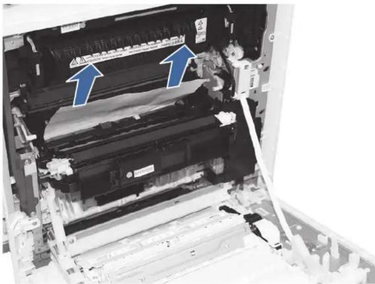 Black-and-white photo of a printer internal structure with blue arrows pointing to components, showing text labels and warning signs.