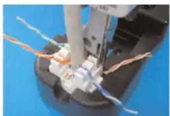 Close-up of a mechanical component with wires and a tool, no visible text or symbols