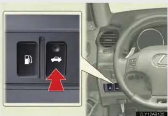 Car interior control panel with fuel pump icon and car symbol, showing red arrow pointing to a car