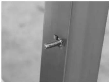 Close-up of a metallic screw fastener inserted into a vertical metal bracket (no text or symbols visible)