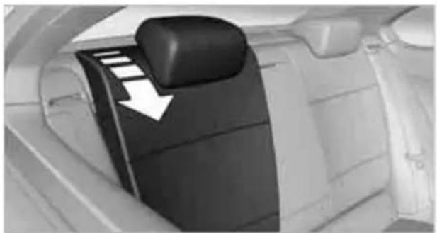 Interior view of a car showing the backrest door and seat, with a white arrow pointing to the side panel (no text or symbols visible)