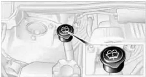 Interior view of a car engine bay with two circular switches and a tool inserted (no visible text or symbols)