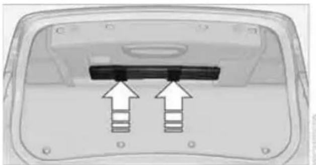 Top-down view of a device rear panel with two black buttons and arrows pointing to the button (no text or symbols visible)